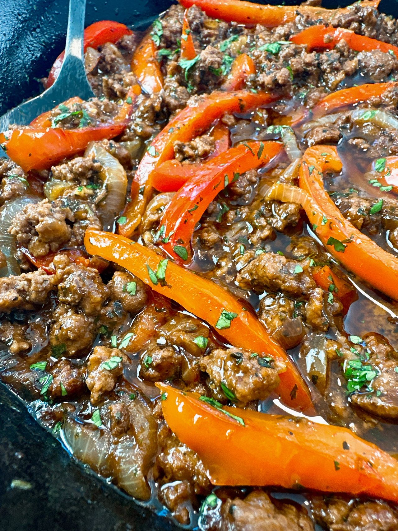 ground beef and peppers in a cast iron skillet