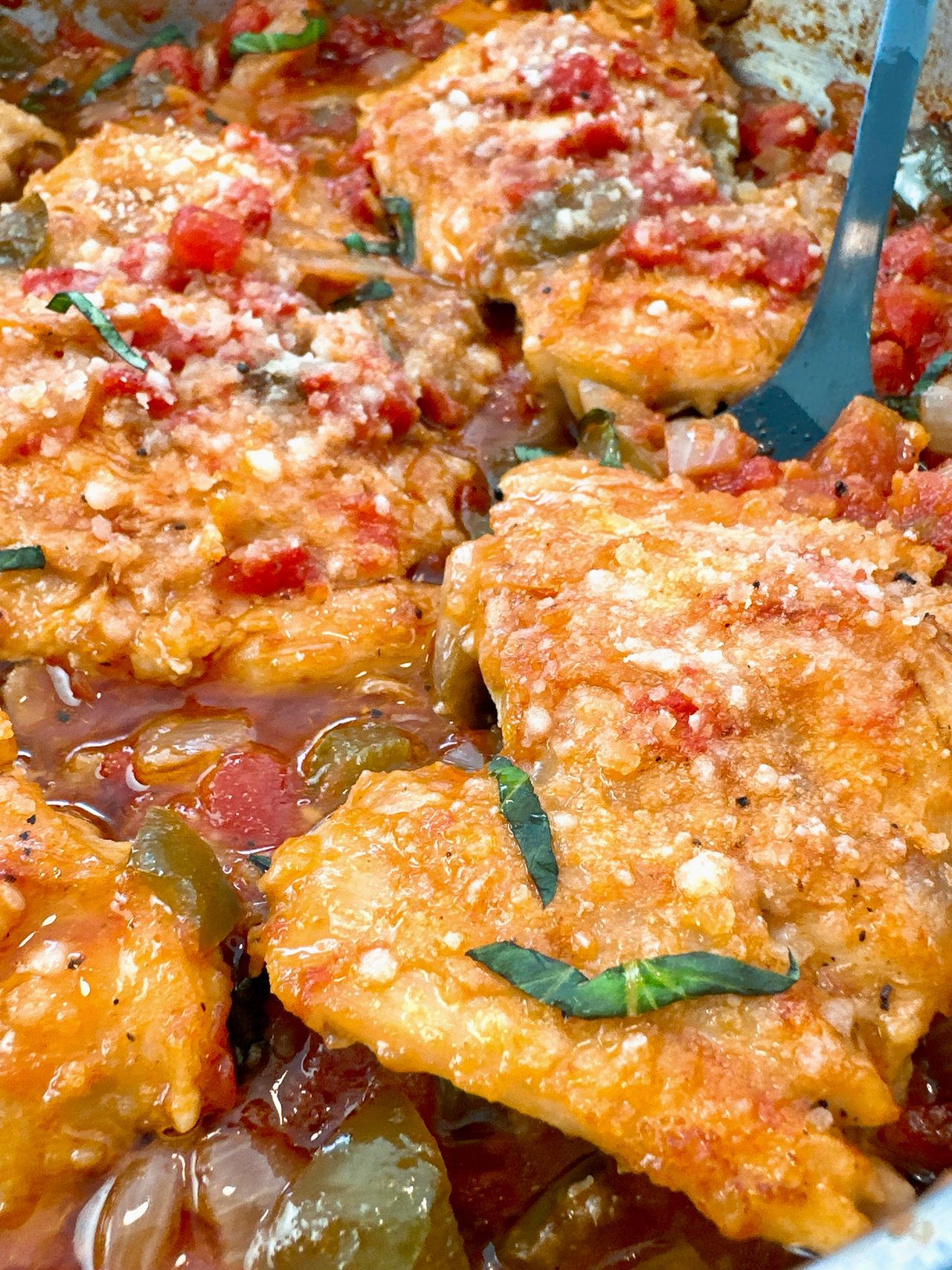 chicken thighs and vegetables in a skillet
