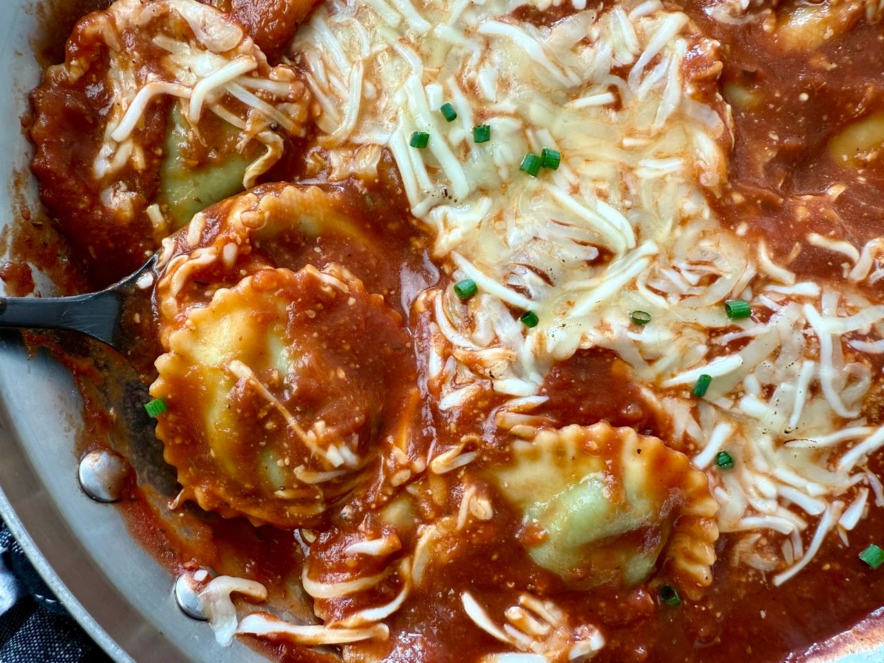spinach ravioli and marinara sauce with mozzarella cheese