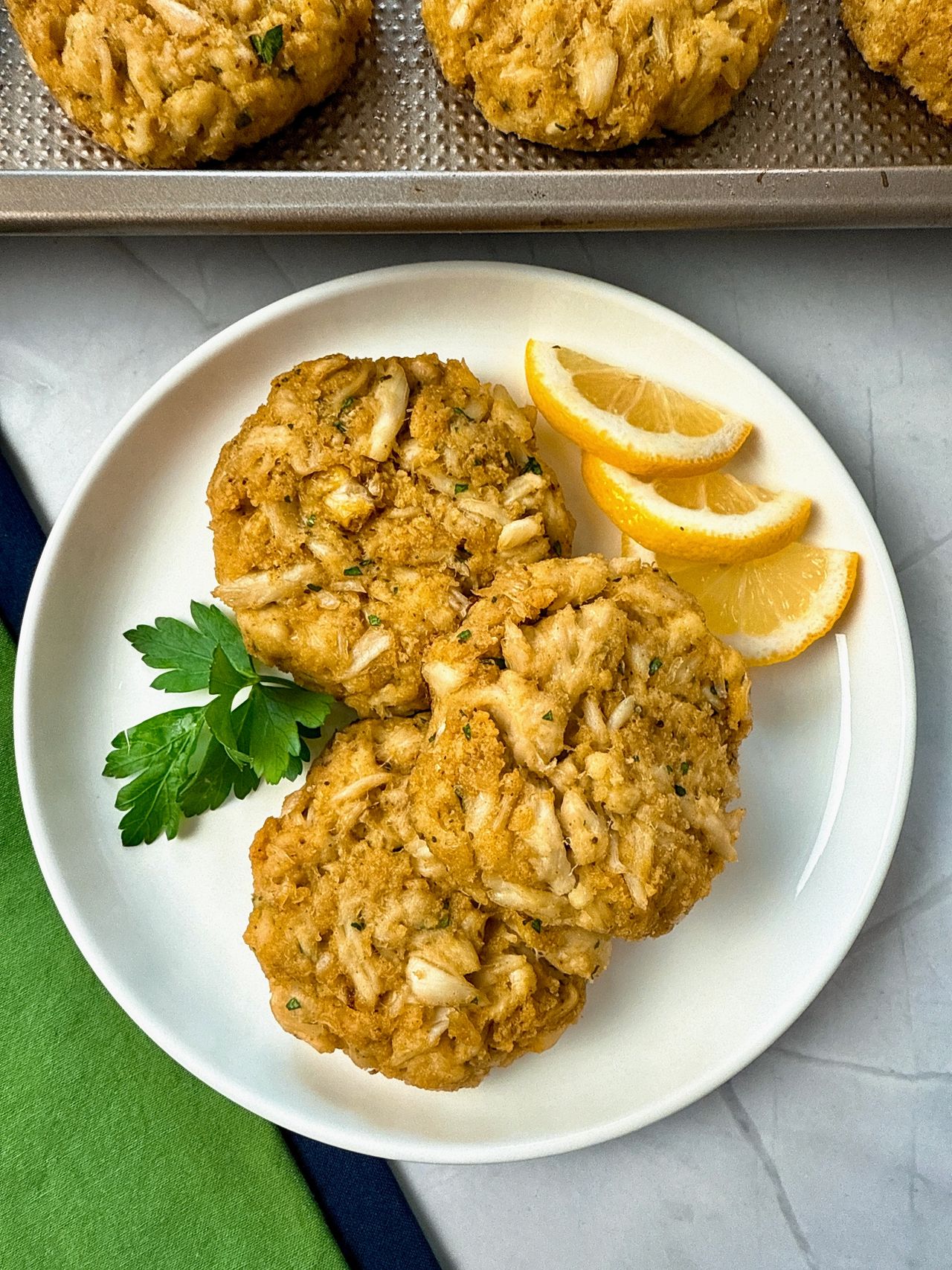 crab cakes and lemon slices on a white plate