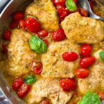 chicken and grape tomatoes with pesto in a silver pan