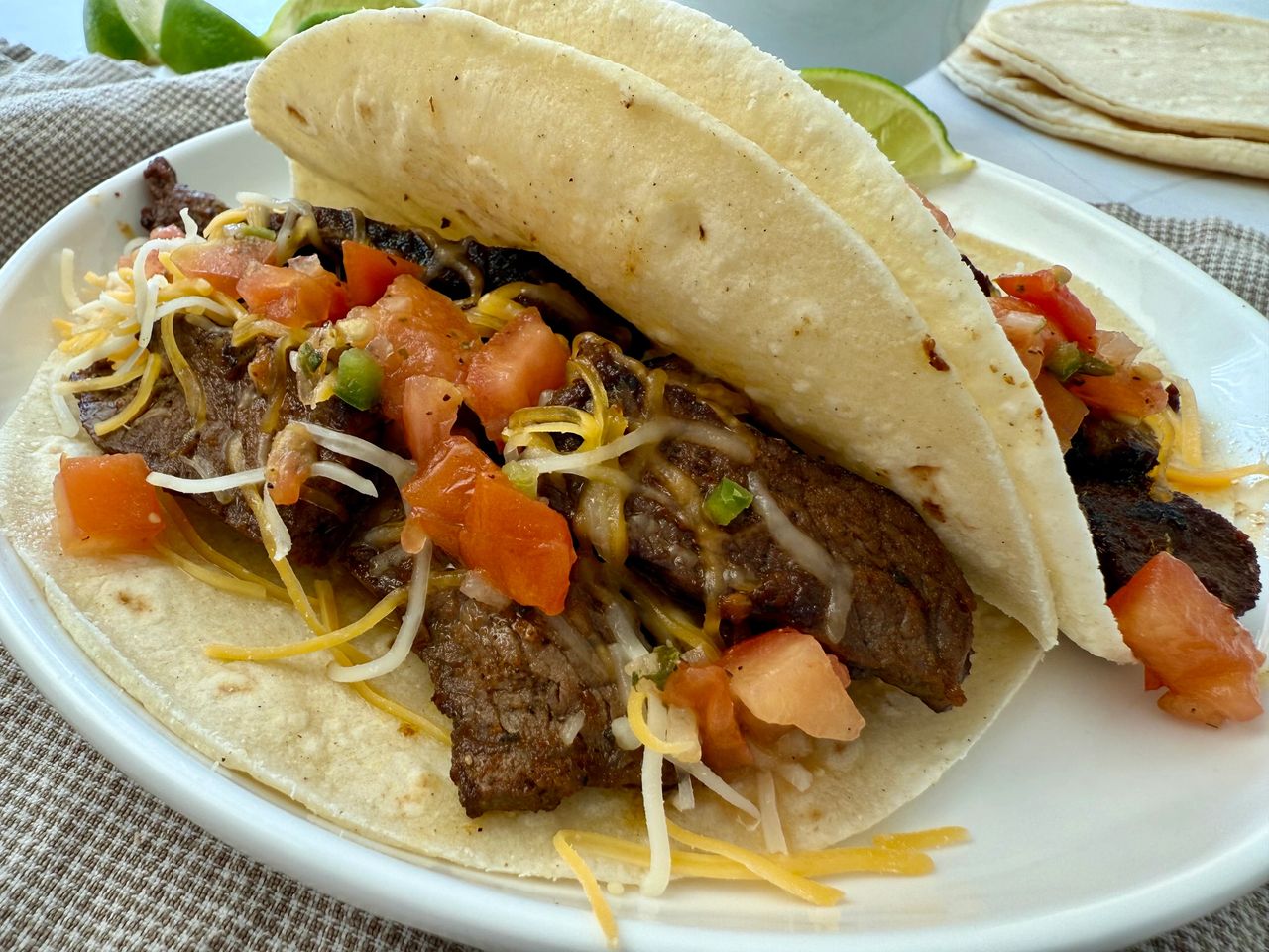 steak street tacos on a white plate with lime garnish