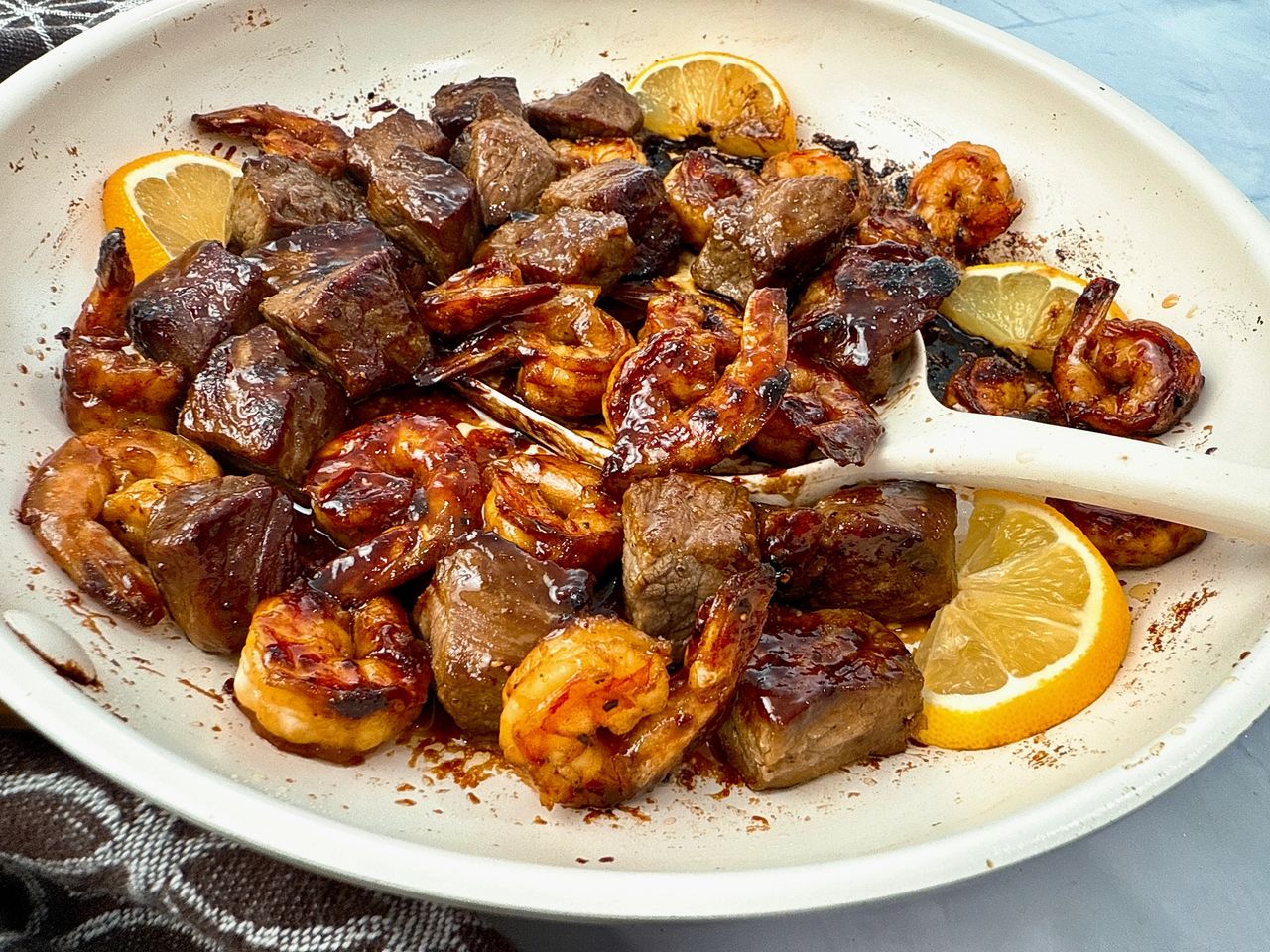 steak and shrimp in a white skillet