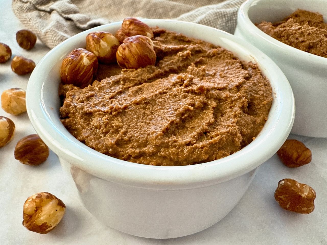 hazelnut spread in a white ramekin with a butter knife