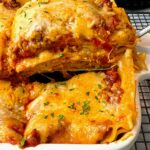 slice of lasagna from a white baking dish