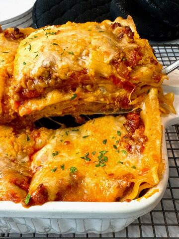 slice of lasagna from a white baking dish
