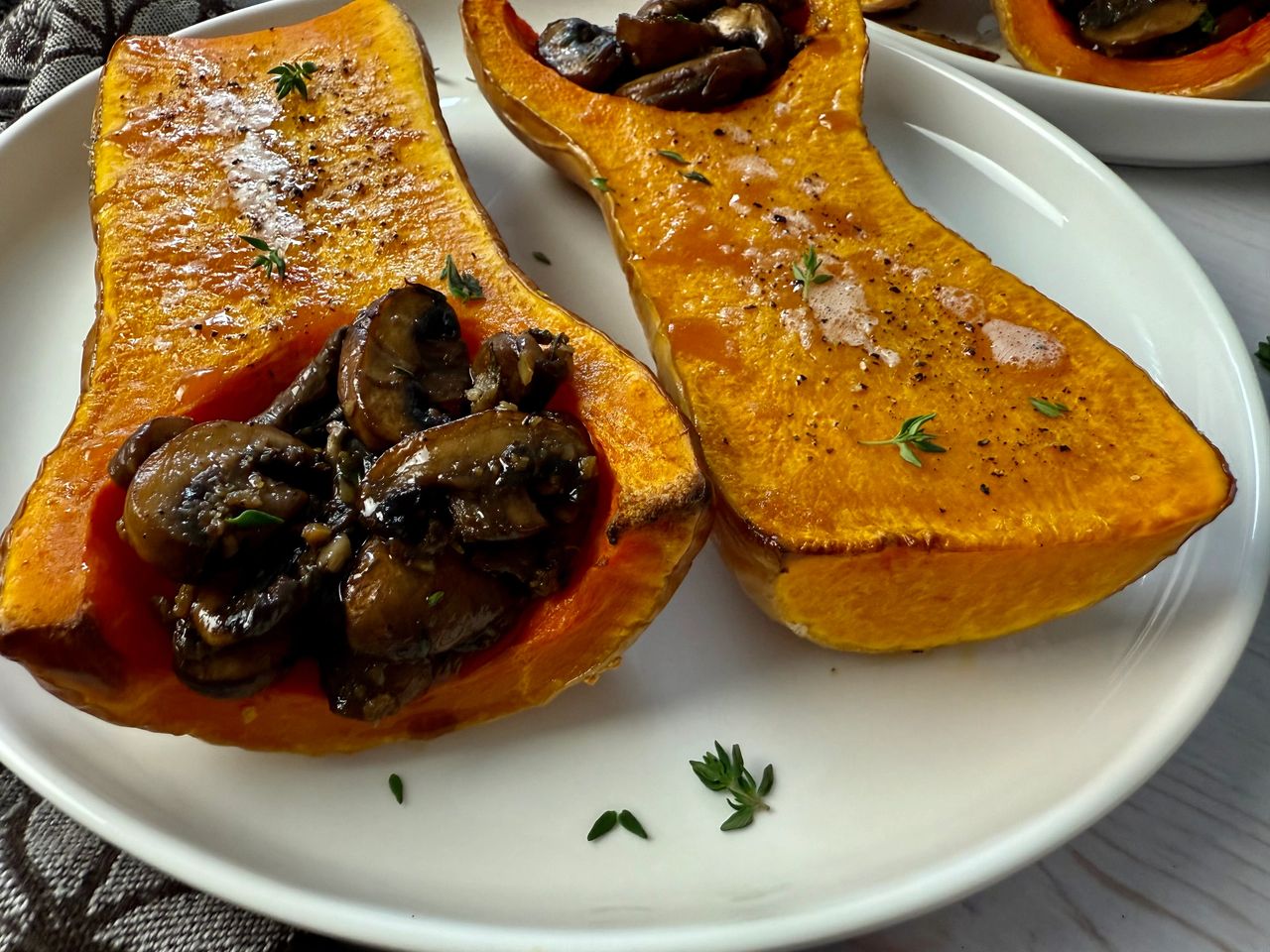 butternut squash stuffed with mushrooms on a white plate