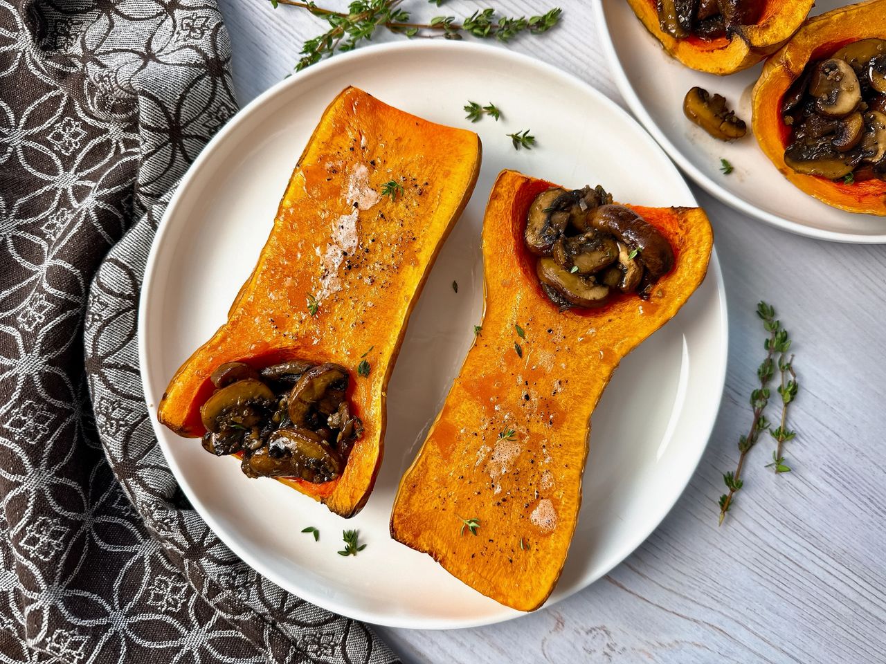 butternut squash stuffed with mushrooms on a white plate