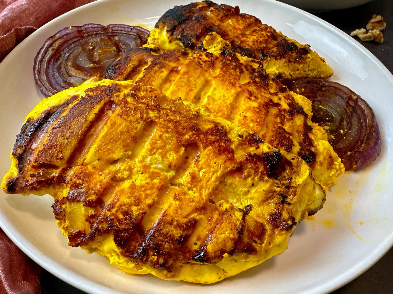saffron chicken and red onion on a white plate