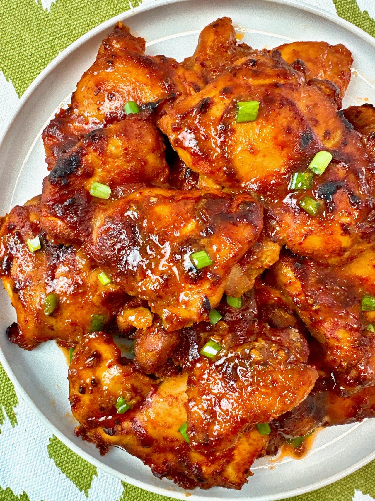 gochujang chicken thighs on a white plate