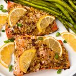 salmon on a white plate with lemon slices