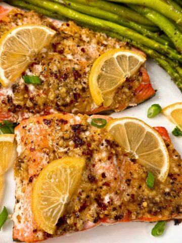 salmon on a white plate with lemon slices