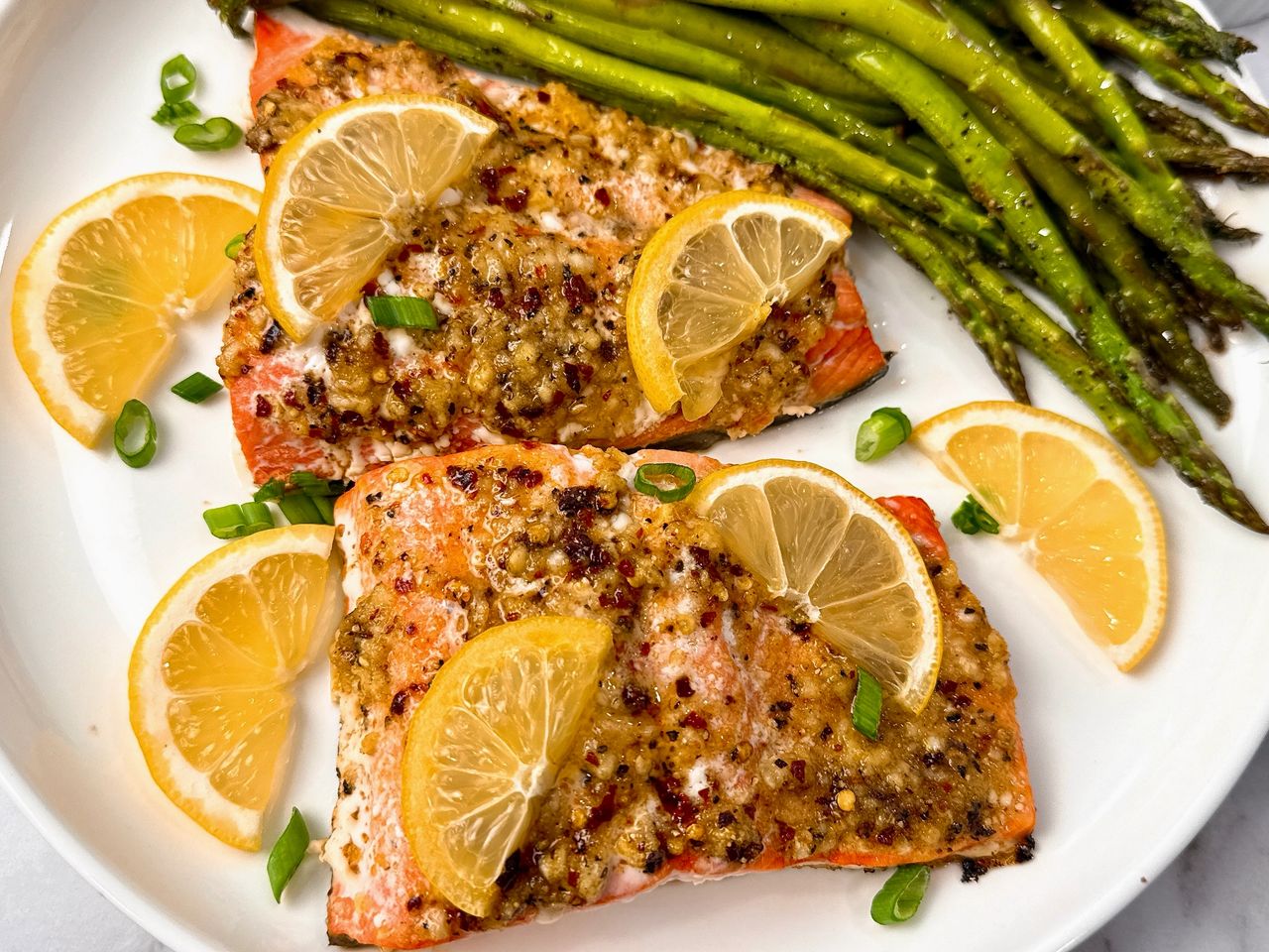 salmon on a white plate with lemon slices