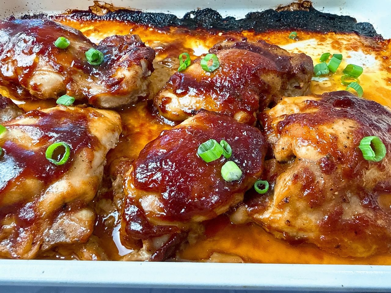 chicken thighs and teriyaki glaze on a baking sheet