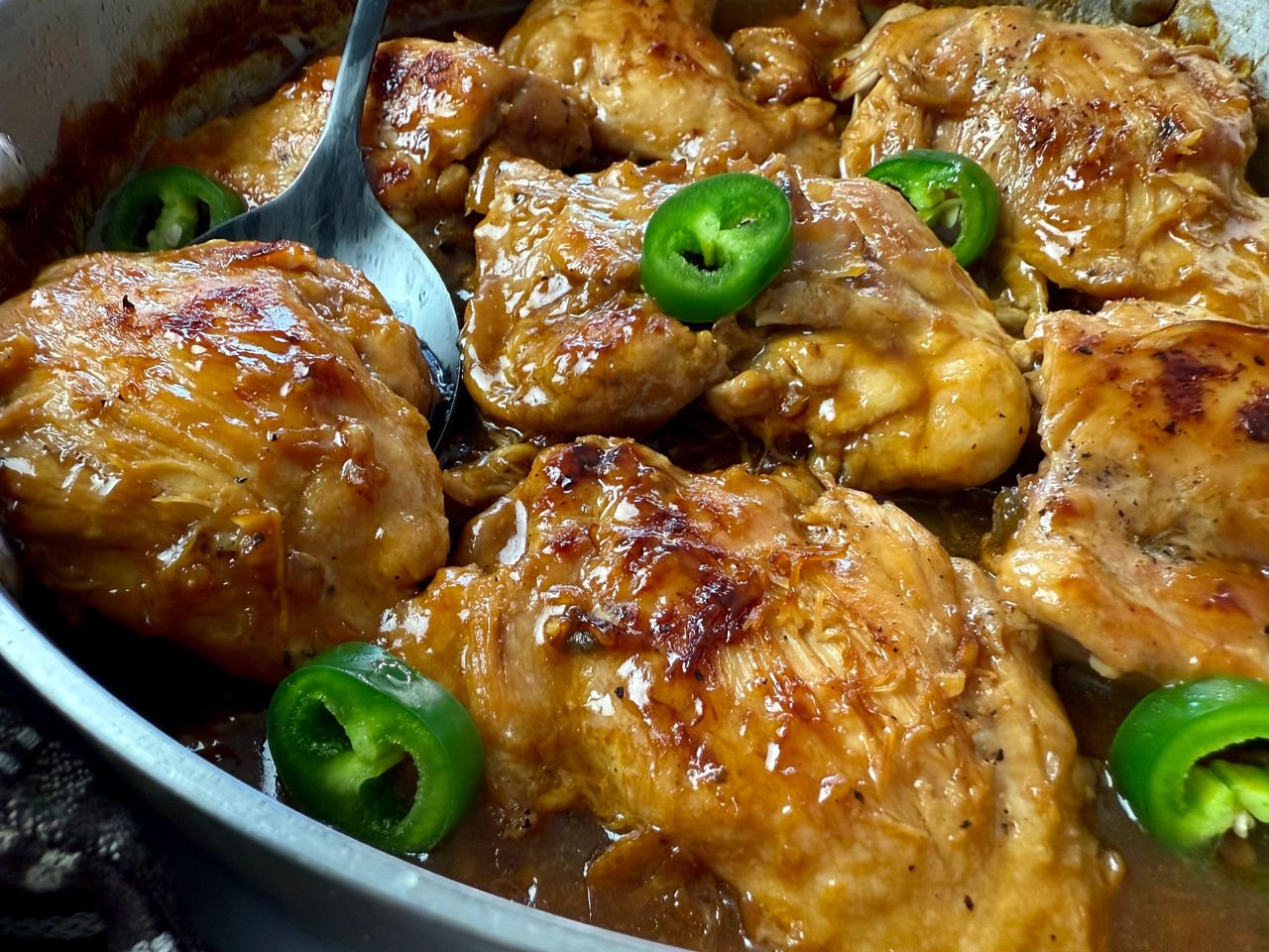 chicken thighs and jalapeno peppers in a silver pan