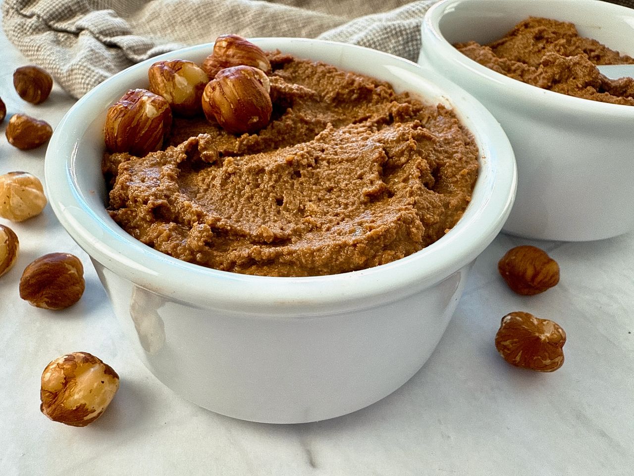 hazelnut spread in a white ramekin with a butter knife