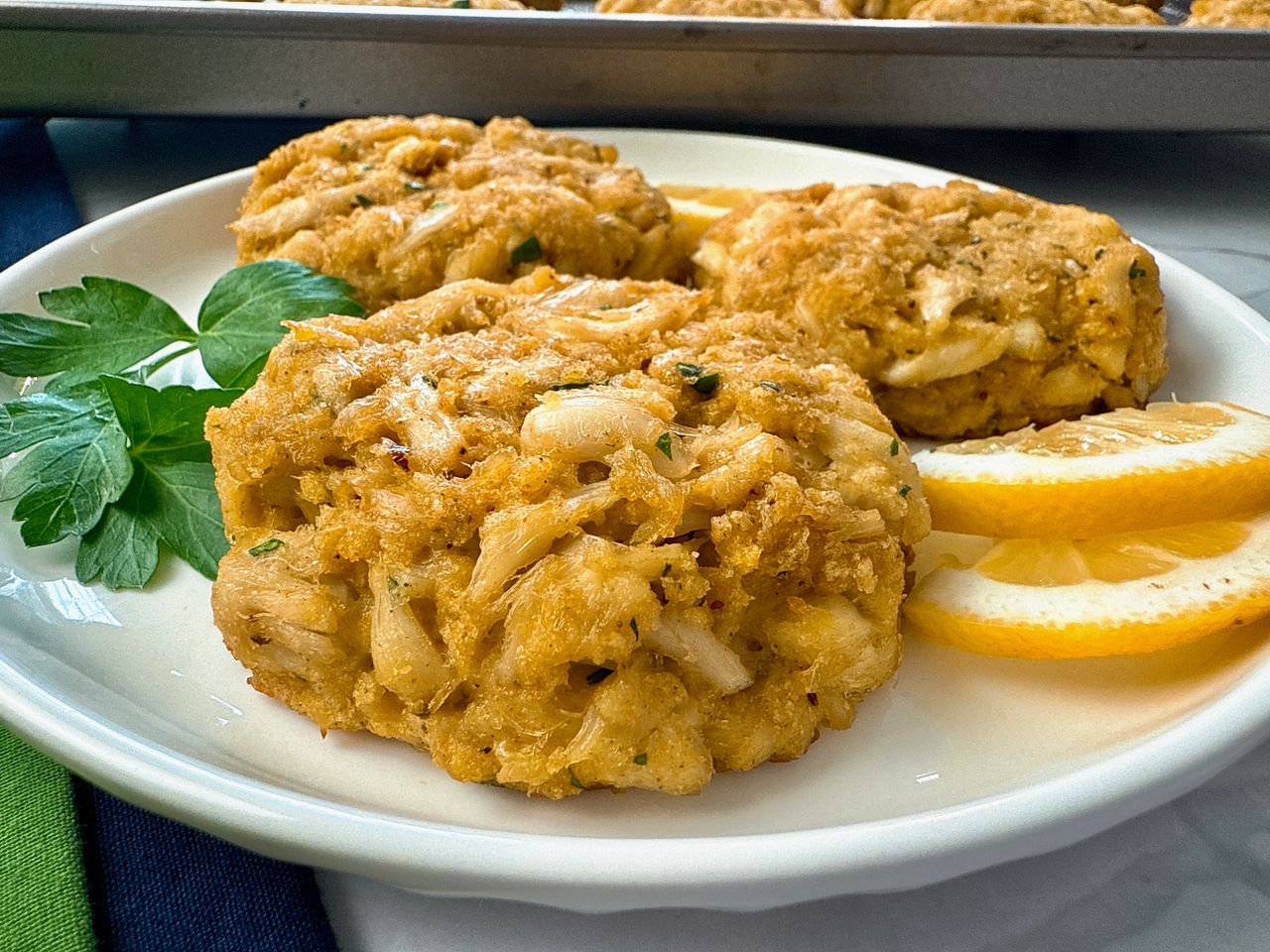 crab cakes and lemon slices on a white plate