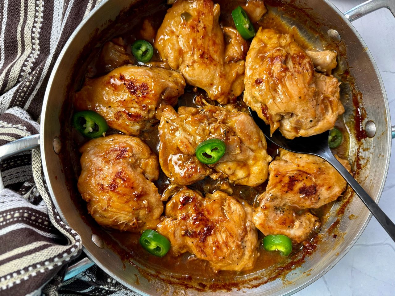chicken thighs and jalapeno peppers in a silver pan
