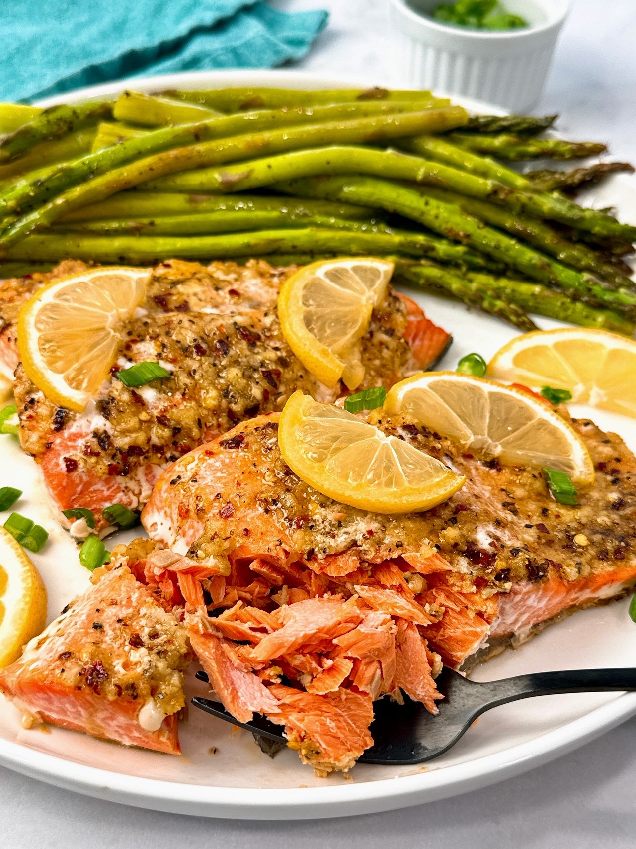 salmon on a white plate with lemon slices
