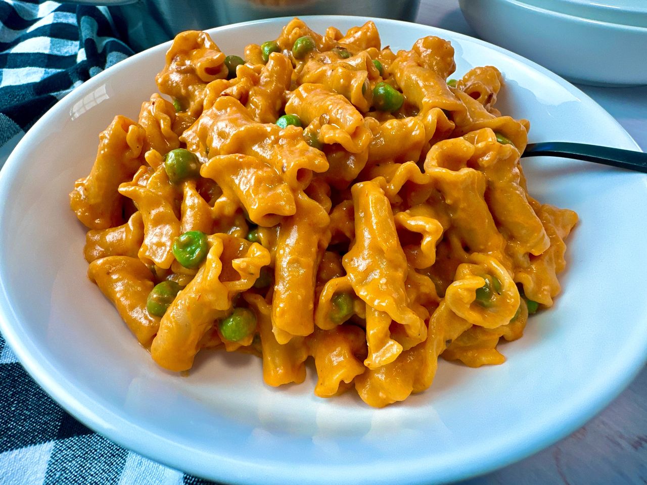 pasta and peas in a white bowl