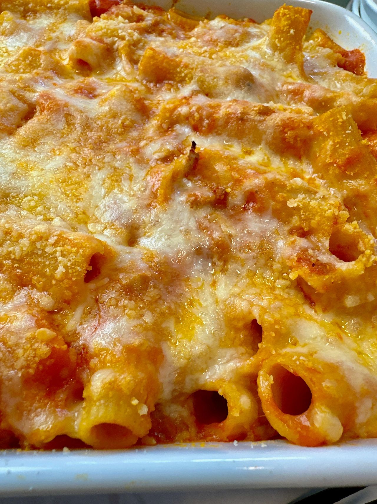 pasta and sausage in a casserole dish and white bowl