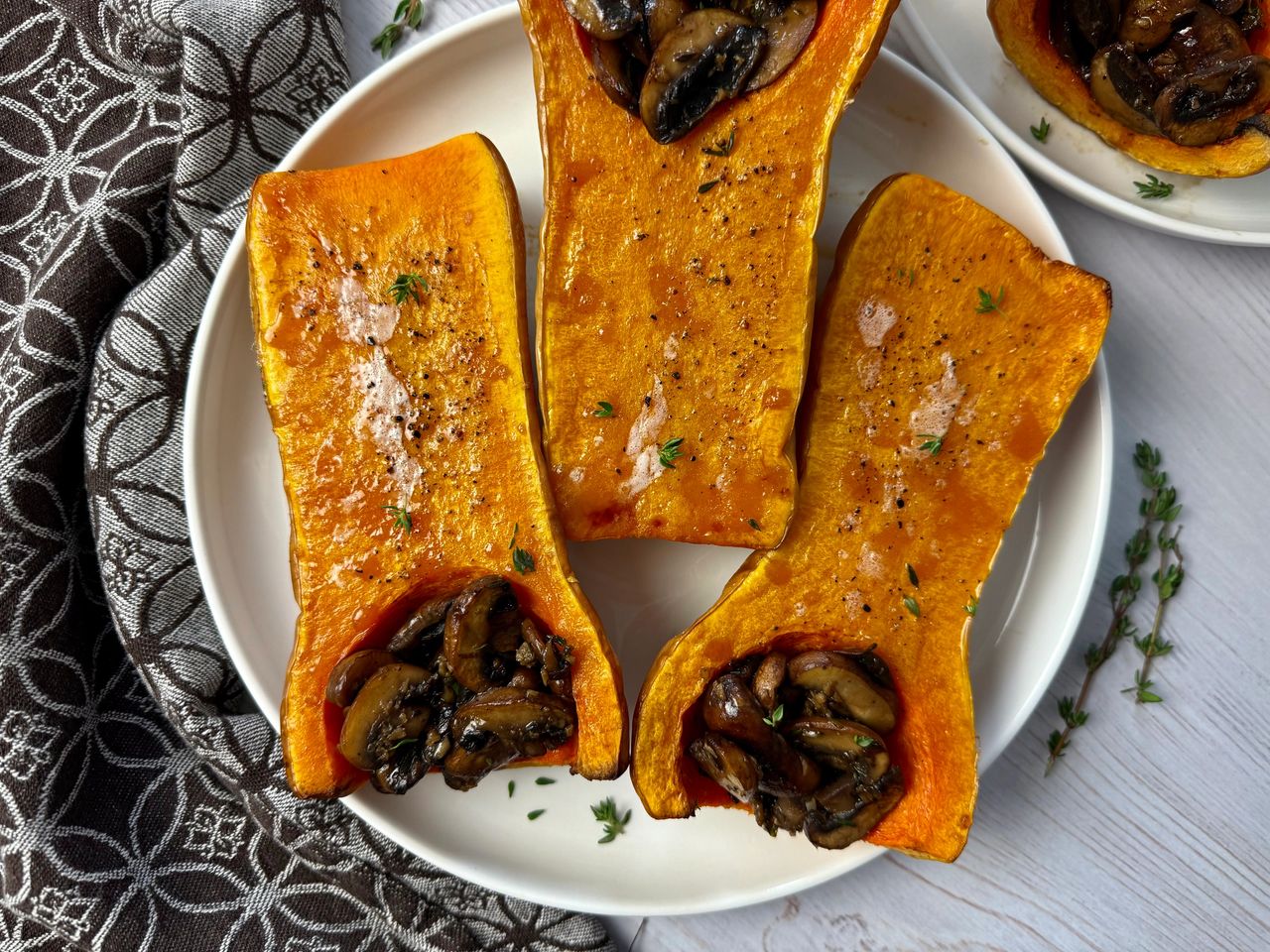 butternut squash stuffed with mushrooms on a white plate