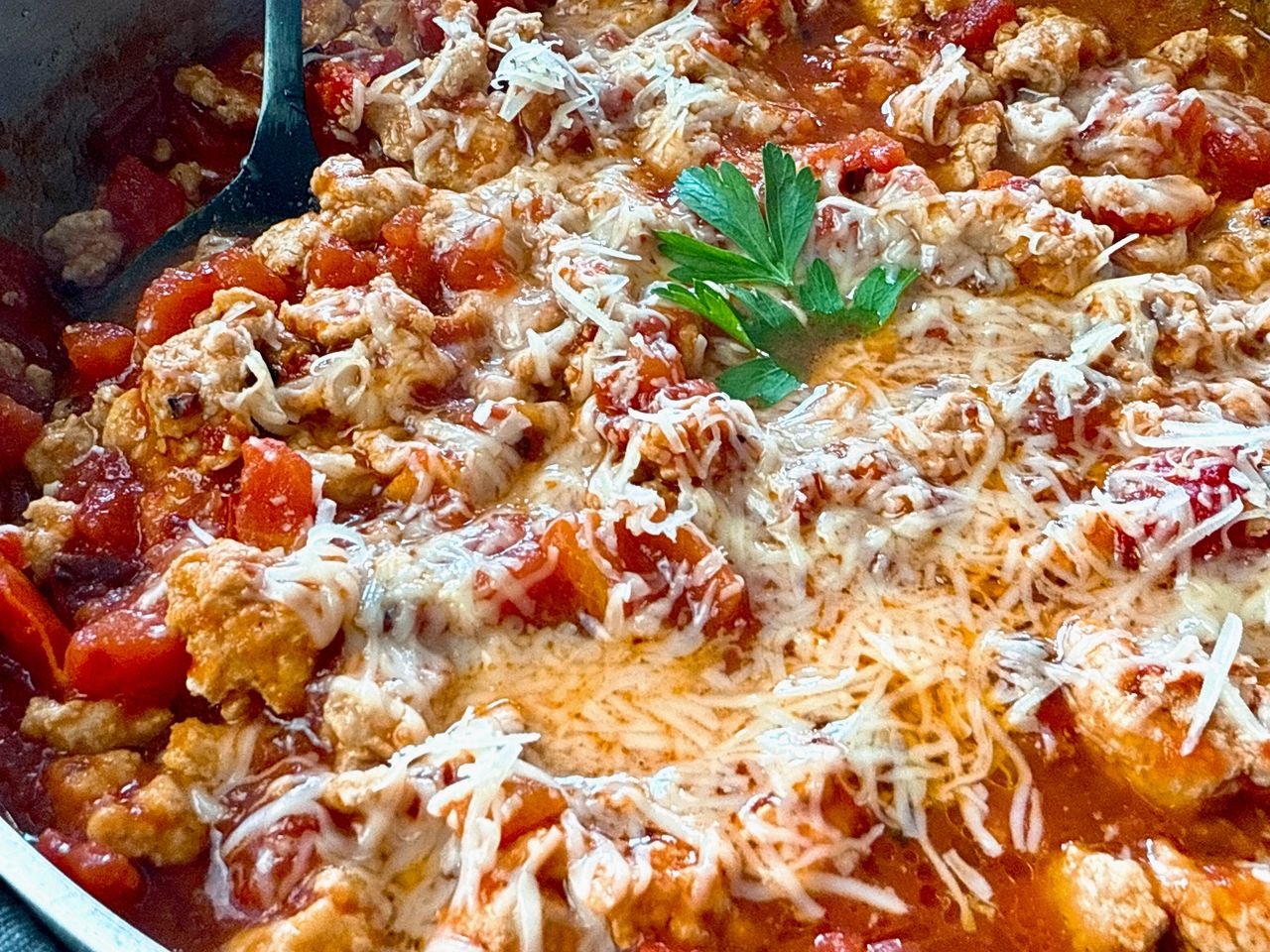 ground chicken arrabbiata with cheese in a silver pan