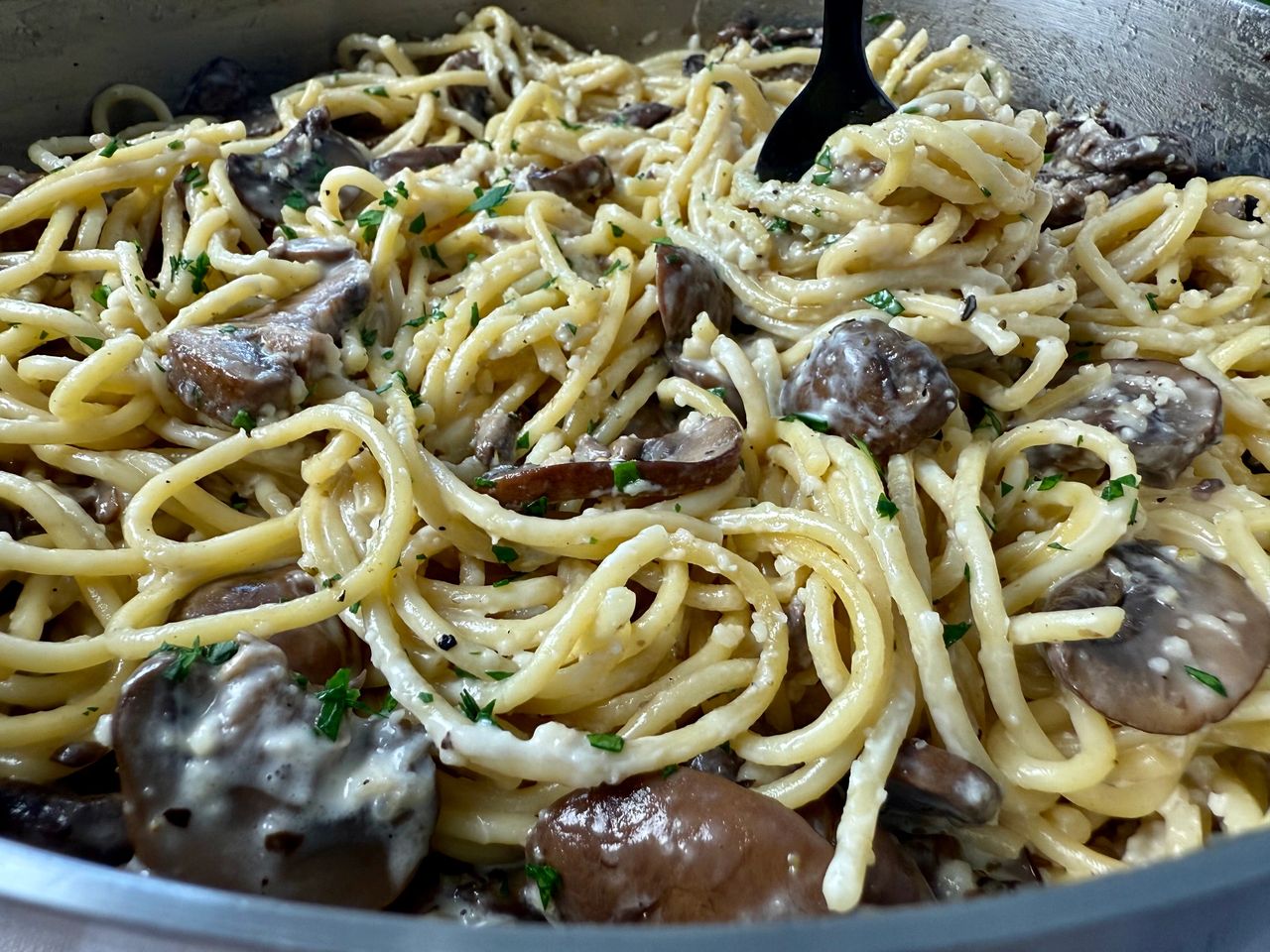 Pasta with Mushrooms in a skillet with a black fork