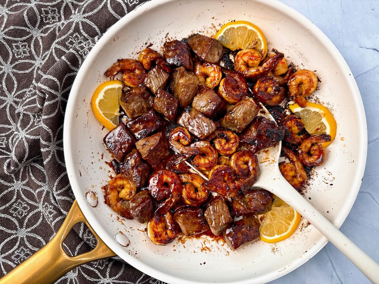 steak and shrimp in a white skillet