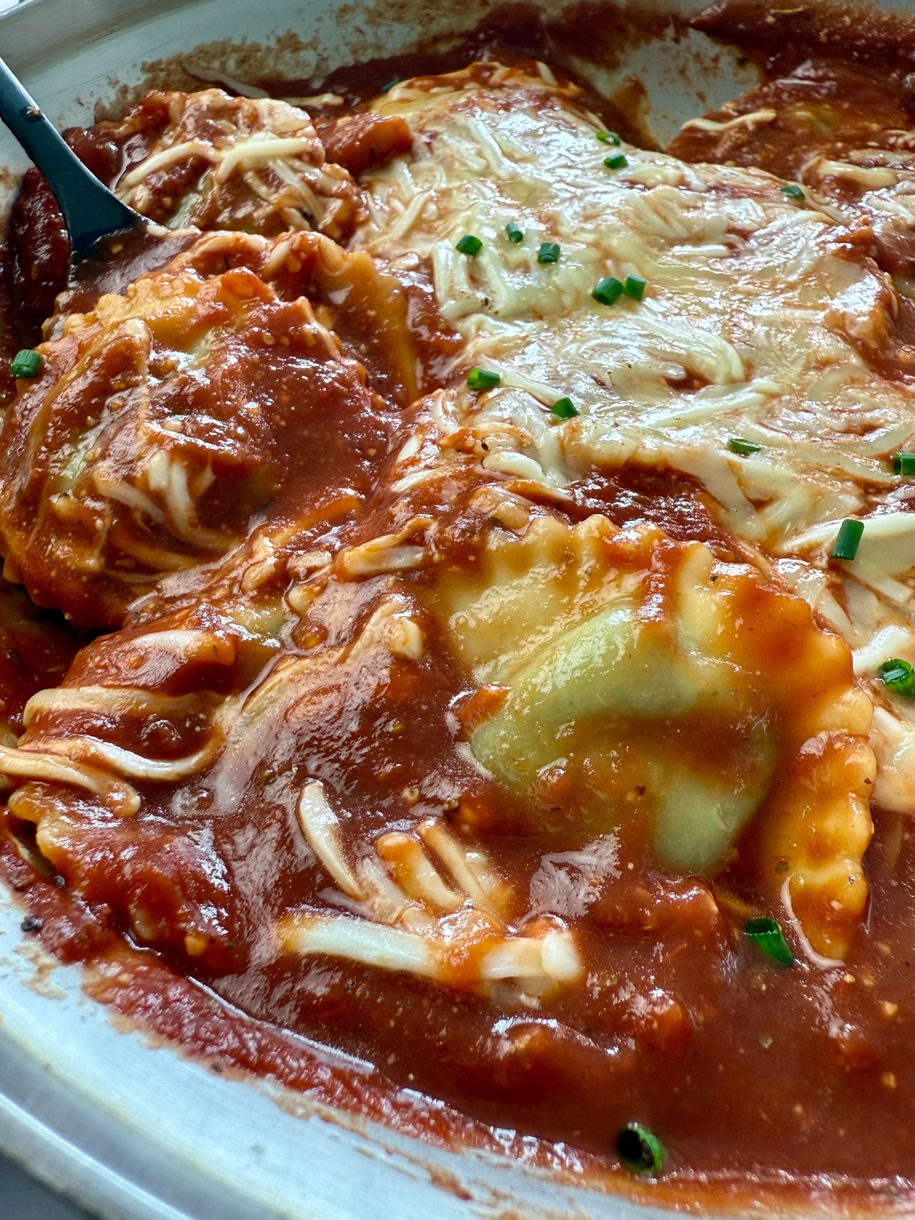 spinach ravioli and marinara sauce with mozzarella cheese