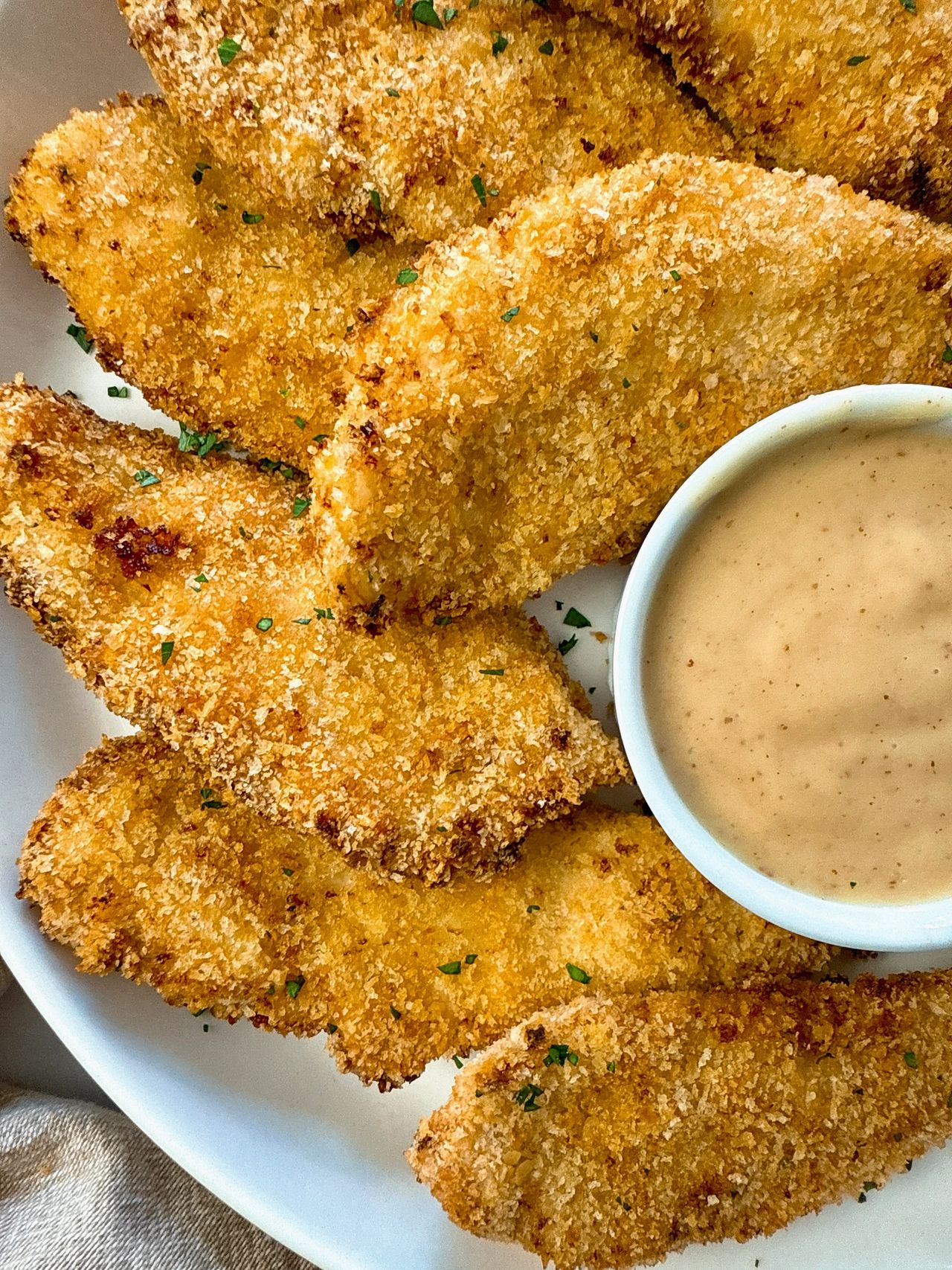 baked chicken fingers and honey mustard dip on a white plate