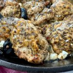 chicken thighs in a cast iron skillet with feta and olives