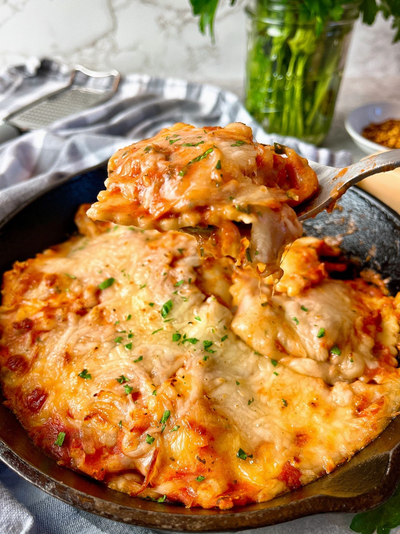 ravioli in a skillet covered with cheese