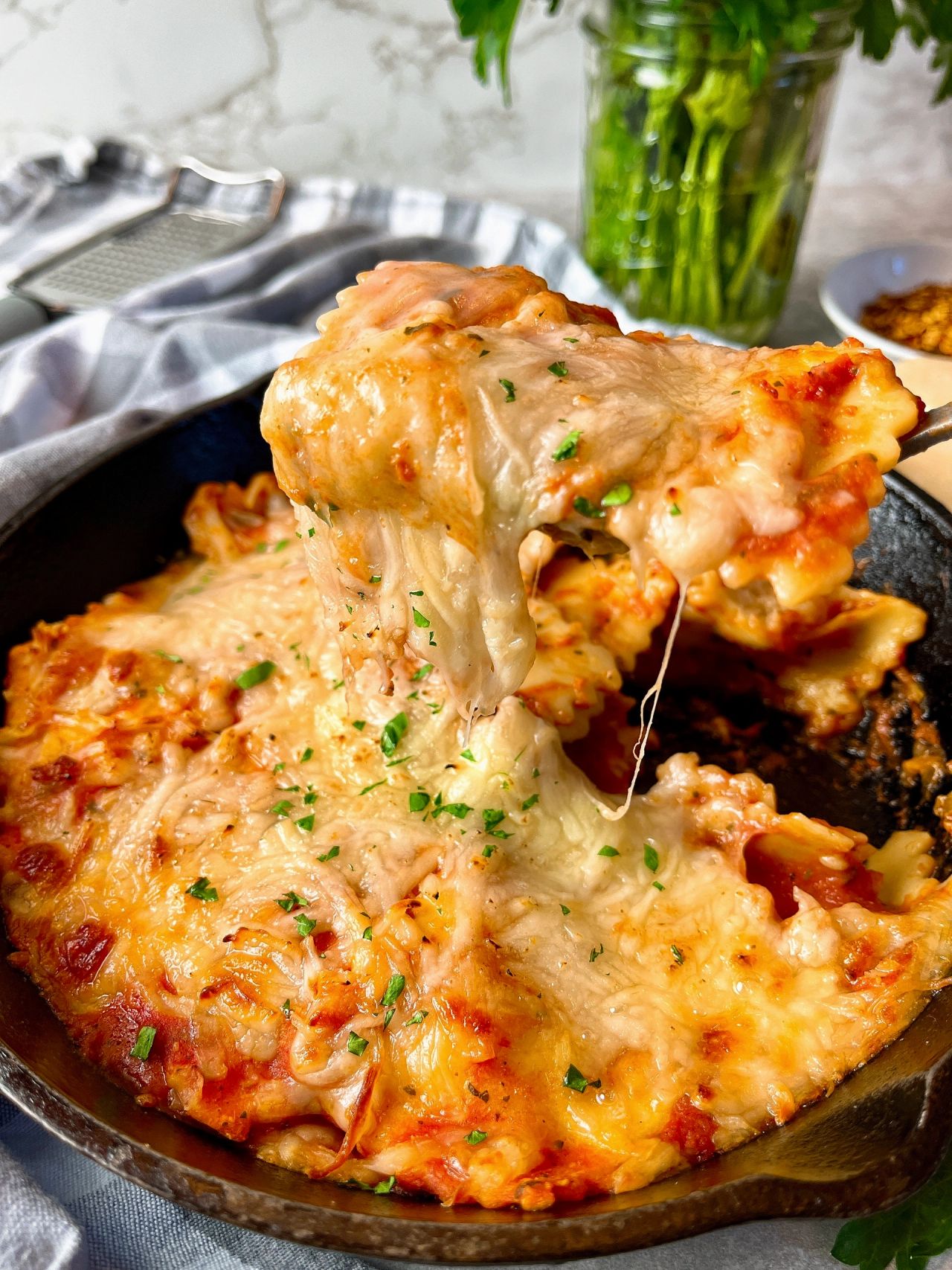 ravioli in a skillet covered with cheese